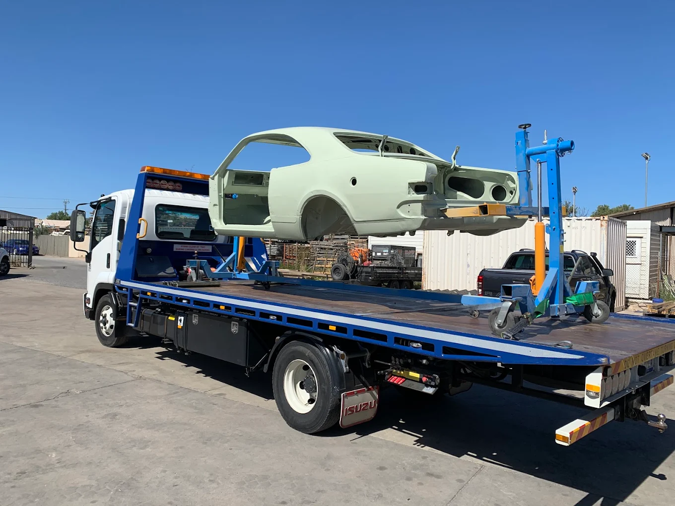 Vehicle body shell transported by an Adelaide tilt-tray tow truck for a panel shop
