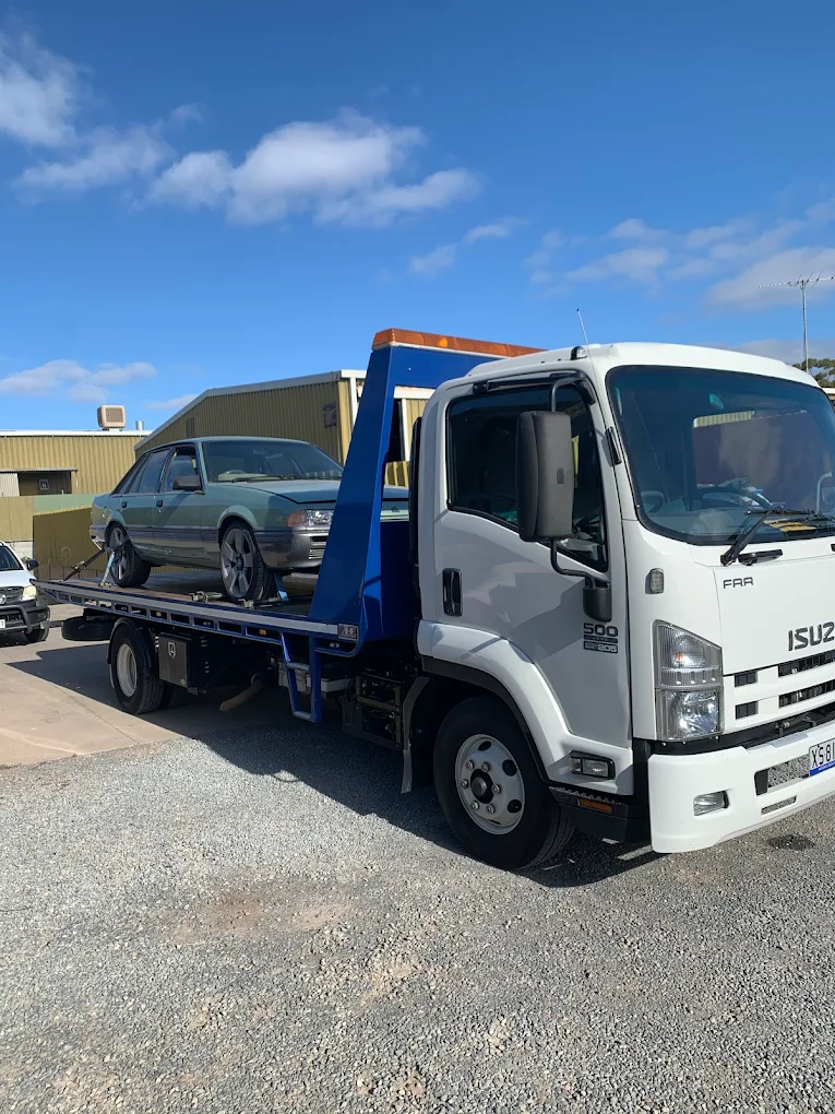 Classic Holden Commodore loaded onto an Adelaide On Call Towing tilt-tray tow truck